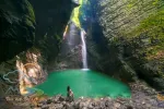 Fashionable girl in swimsuit relaxes in front of the Kozjak Waterfall, Slovenia