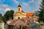 Scenic view of Kutna Hora with old house rooftops and Ursuline Convent Church in city center, Czech Republic