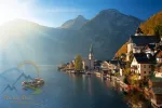 Scenic view of famous Hallstatt mountain village in the Alps with traditional passenger ship at autumn morning
