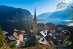 Amazing view of famous Hallstatt mountain village with lake and Alps mountains on background at autumn morning